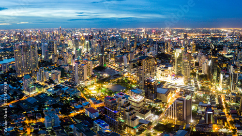 Aerial view of Bangkok skyline and skyscraper on Sukhumvit center of business in capital. Panorama of modern city and BTS skytrain with Benjasiri park on Asoke junction in Bangkok Thailand at night