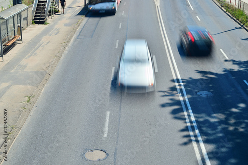Rozmyte sylwetki samochodów podczas jazdy na dwupasmowej jezdni.