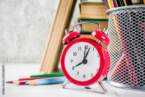 Back to school background with old books, alarm clock, pencils