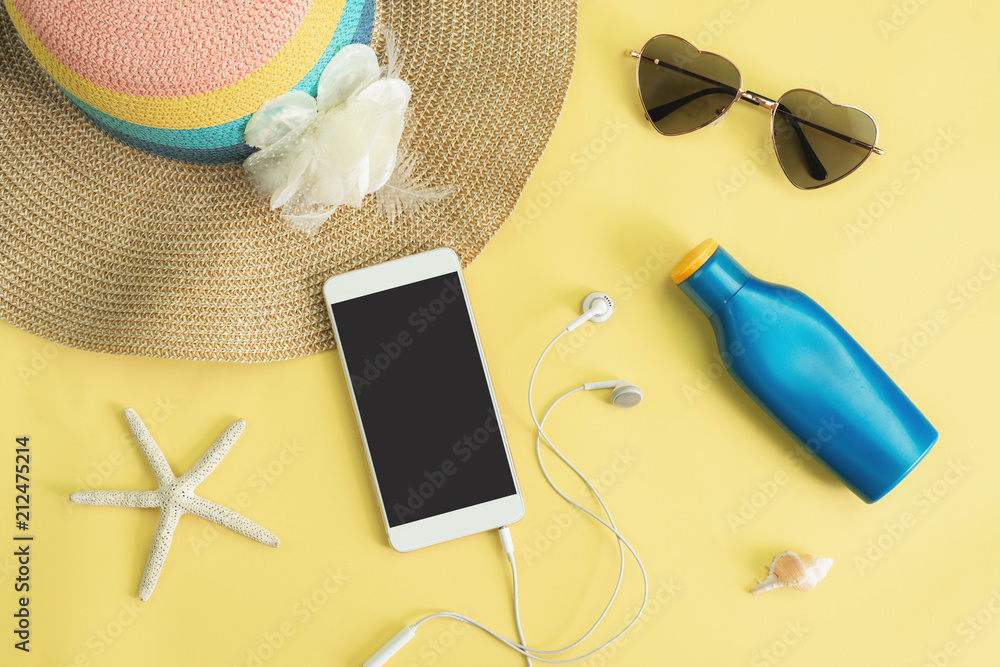 Women's accessories items with smart phone on yellow background, Summer vacation concept Women's accessories items with smart phone on yellow background, Summer vacation concept