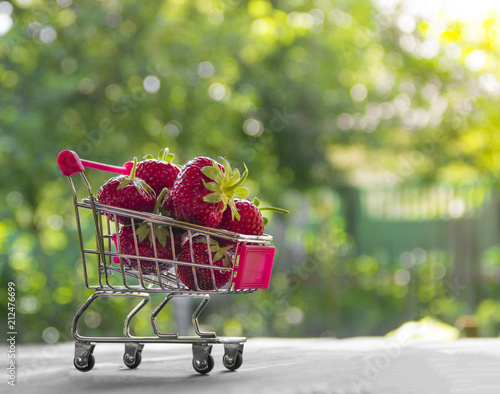 on a green background round bokeh trolley with berries red strawberries place inscription