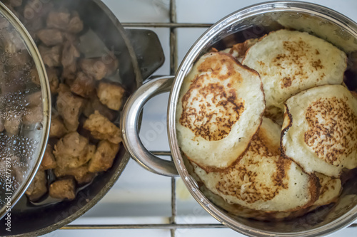 Traditional Russian pancake pancake on a cast-iron frying pan photo