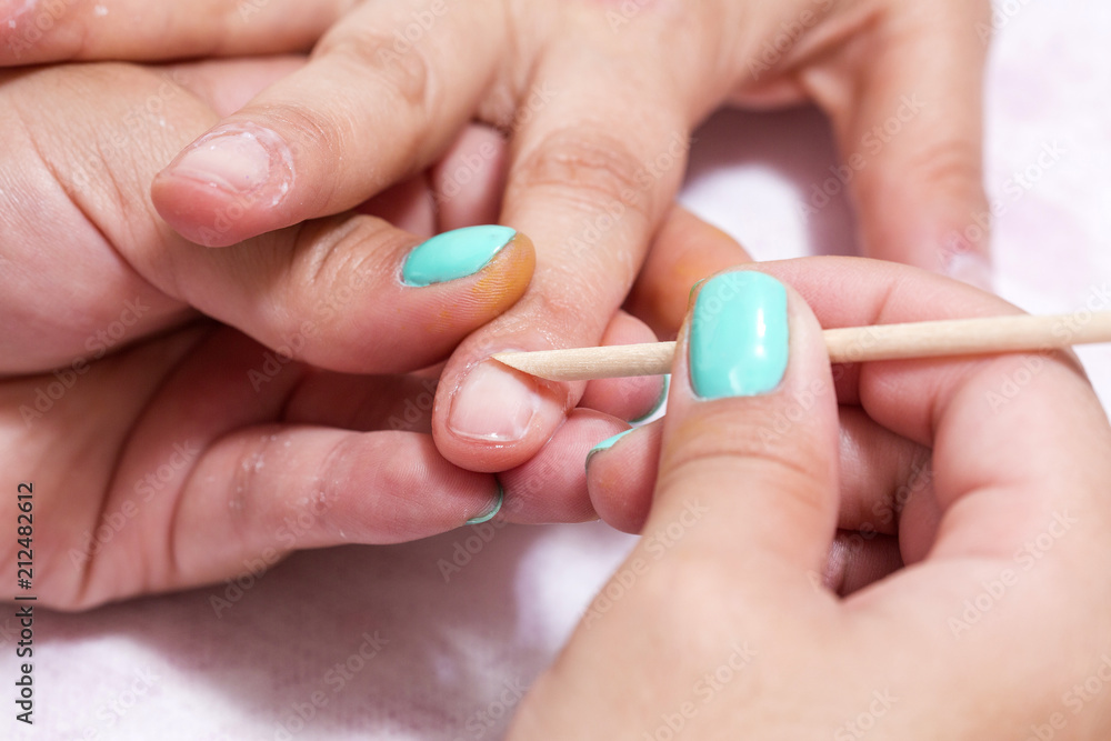Woman in salon receiving manicure by nail beautician Woman in salon receiving manicure by nail beautician