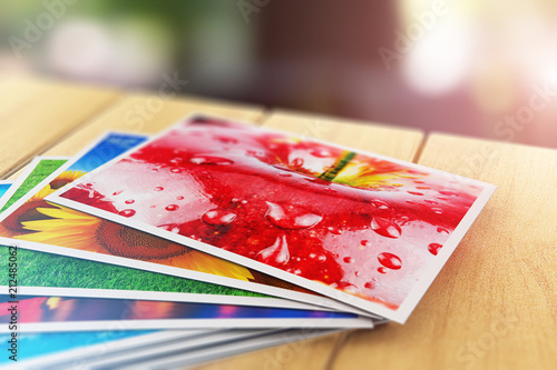 Stack of color photo pictures on wooden table outdoors