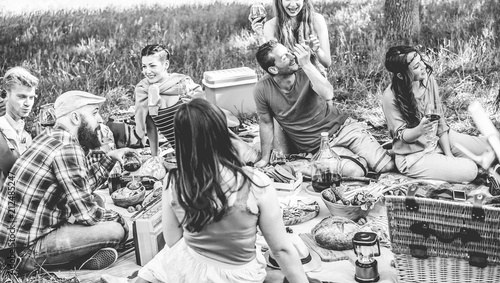 Happy friends doing picnic meal party outdoor in nature