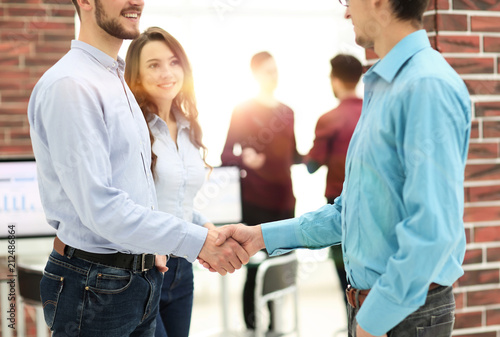 Businesspeople shaking hands before meeting In boardroom.