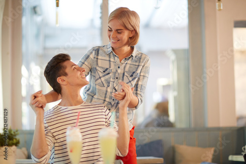 Photos Amorous guy and girl looking at one another during their romantic date in cafe
