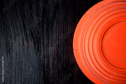 Flying target plate for shotgun sport against the dark wooden background. Copy space