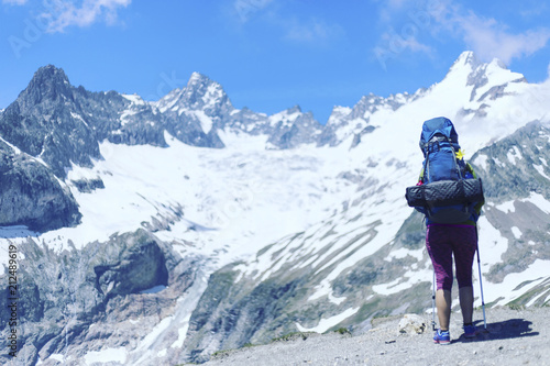 Campaign around Mont Blanc. The girl is walking along the trail with a backpack.