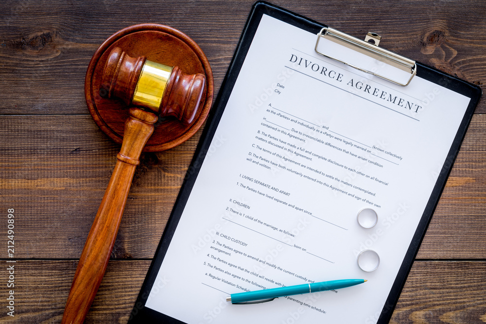 Divorce court case. Divorce agreement near wedding rings and judge gavel on dark wooden background top view