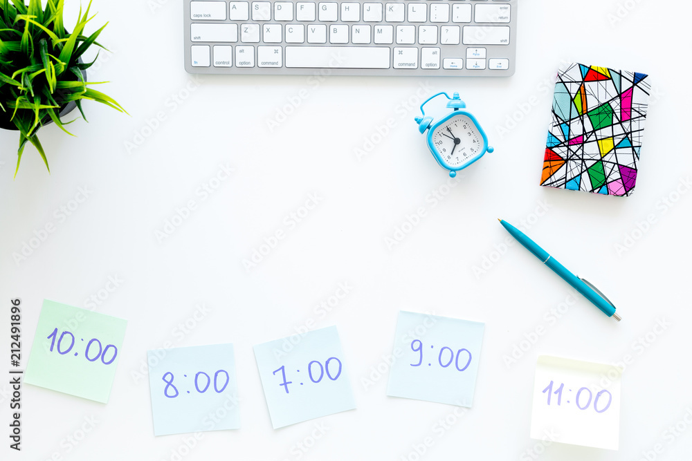 Planning day concept, schedule. Sticky notes with time on work desk with computer, notebook, alarm clock on white background top view copy space Planning day concept, schedule. Sticky notes with time on work desk with computer, notebook, alarm clock on white background top view copy space