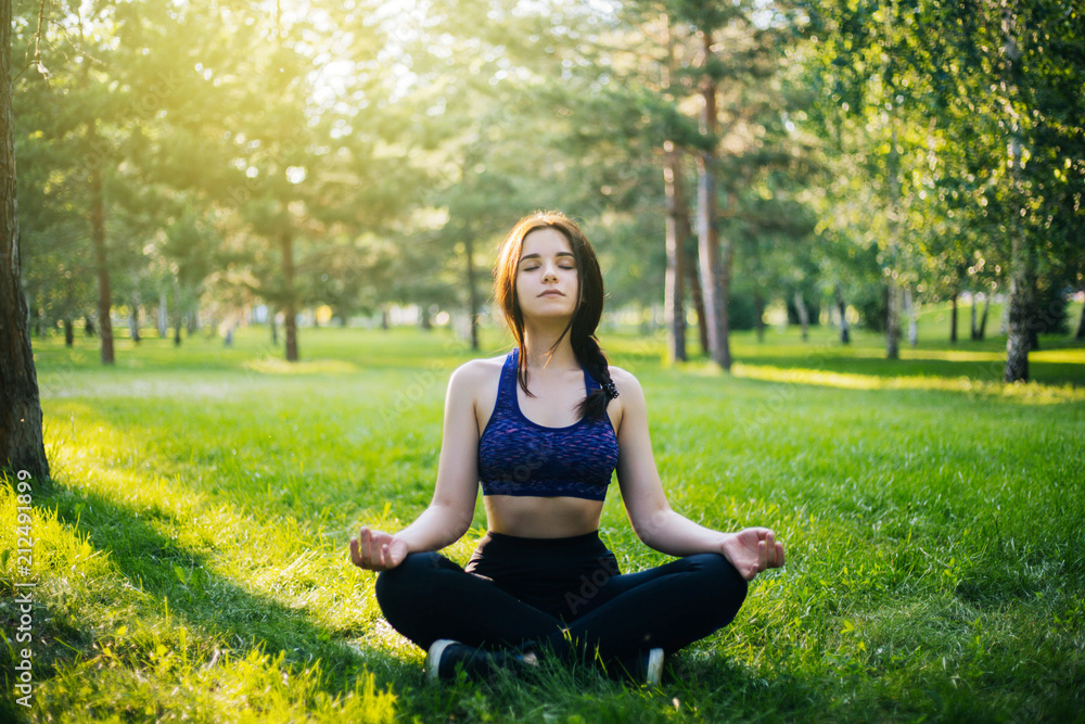 Young beautiful girl practicing yoga in the park. Woman in sportswear. Healthy lifestyle. Young beautiful girl practicing yoga in the park. Woman in sportswear. Healthy lifestyle.