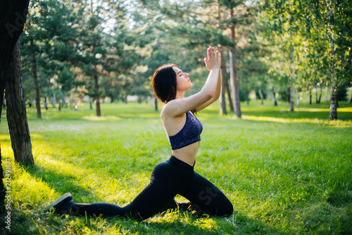 Young beautiful girl practicing yoga in the park. Woman in sportswear. Healthy lifestyle. © Вероника Преображенс
