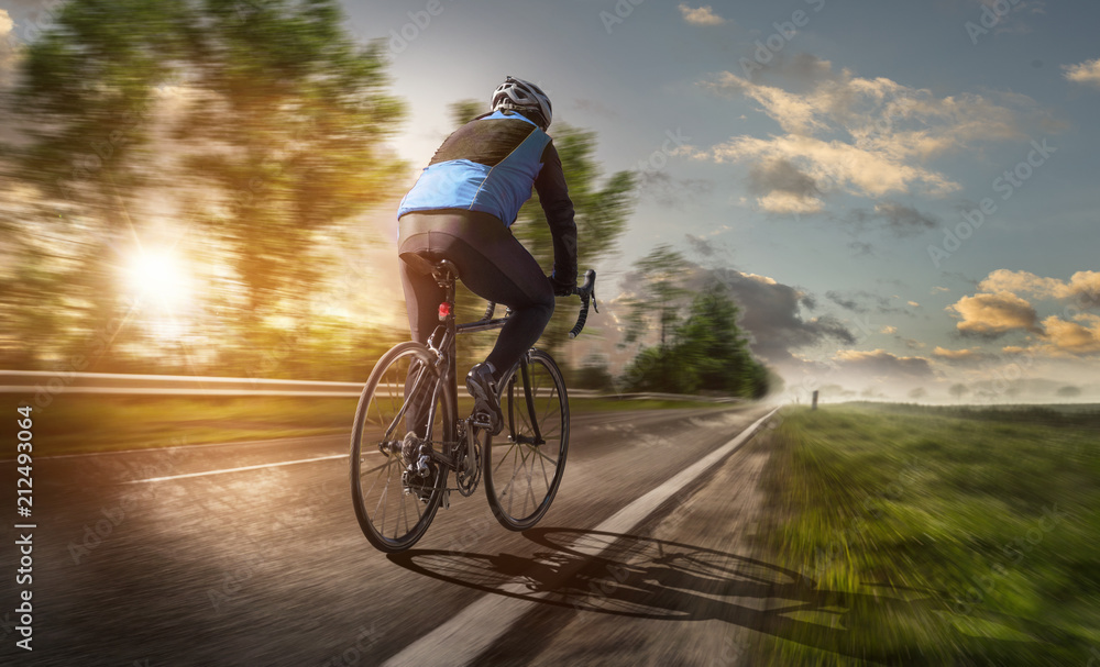 Fototapeta premium Radsportler fährt bei Sonnenuntergang