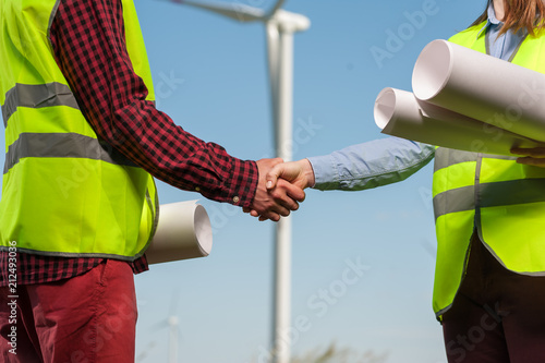 Billede på lærred Chief executive of a woman and a man engineer in green waistcoats are shaking ha