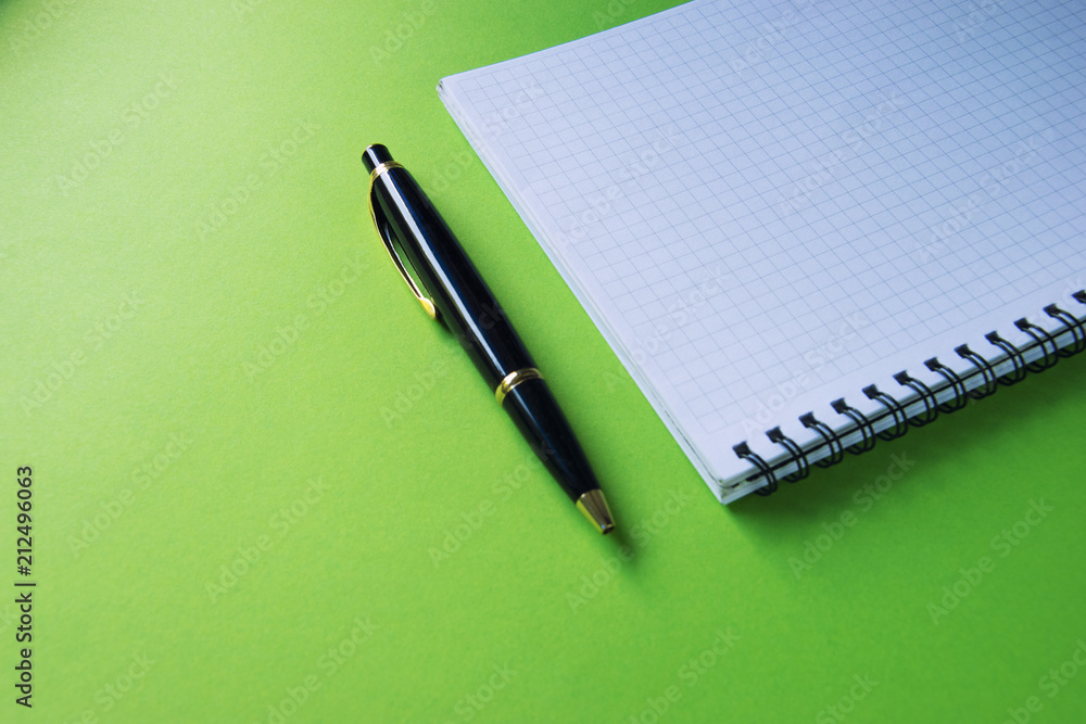 Notepad and pen on a green surface Office supplies, Back to school, office, copy space Notepad and pen on a green surface Office supplies, Back to school, office, copy space