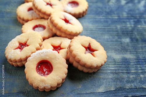 Traditional Christmas Linzer cookies with sweet jam on wooden background