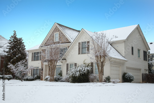 Siding and Stone House in Snow under Blue