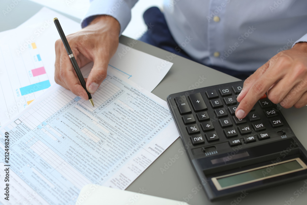 Tax accountant working with documents at table Tax accountant working with documents at table