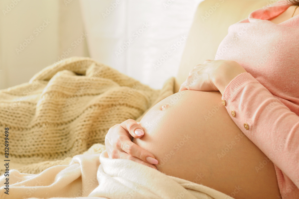 Happy pregnancy sitting on sofa at home Happy pregnancy sitting on sofa at home