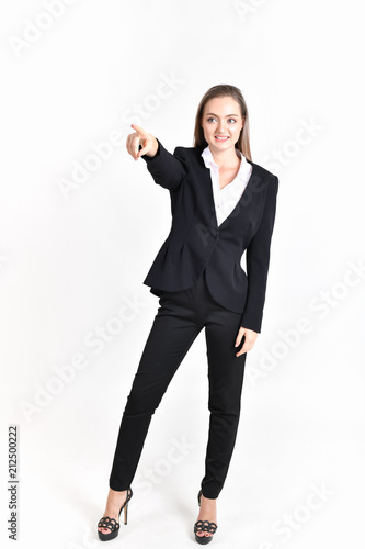 Business Concept. Beautiful businesswoman poses confidently. Young businesswoman pointing on copy space. Beautiful young businesswoman is presenting a job.