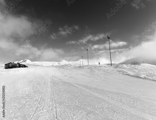 Ski slope and hotel in winter mountains