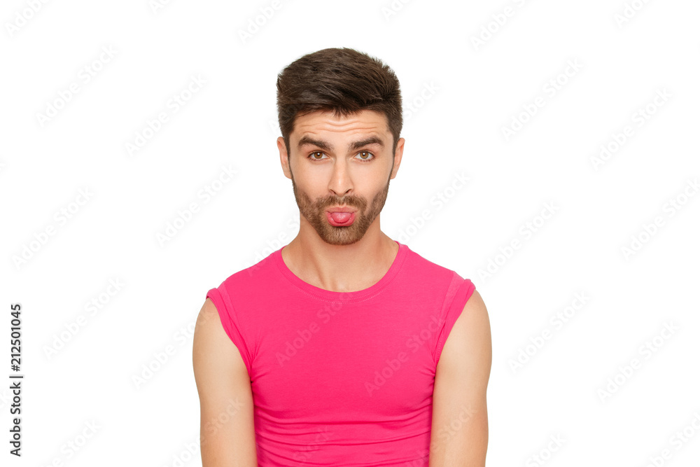 Funny emotional sexy male model in a pink t-shirt on white background Funny emotional sexy male model in a pink t-shirt on white background
