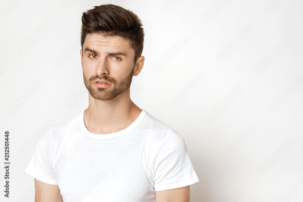 Strong face male model in casual style in white t sirt and jeans on white background Strong face male model in casual style in white t sirt and jeans on white background