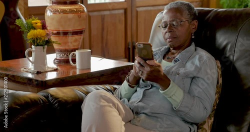 African American elderly woman relaxing with her mobile phone