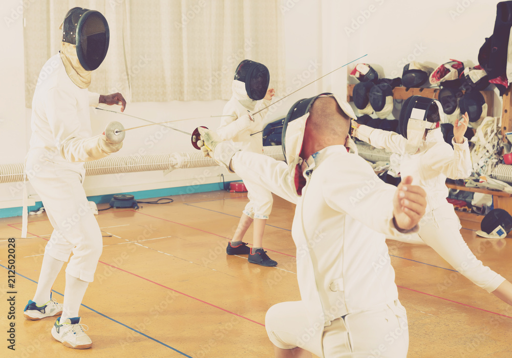 Fototapeta premium Mixed age group of athletes at fencing workout