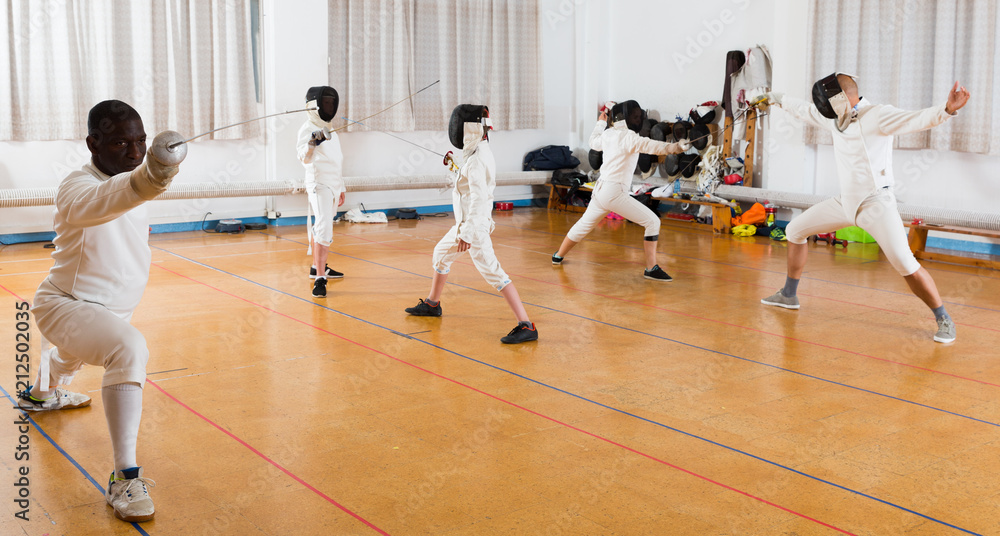adults and children athletes at fencing workout