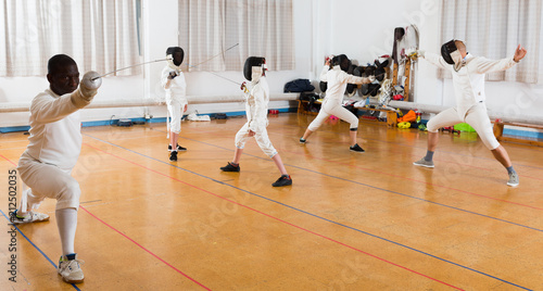 adults and children athletes at fencing workout