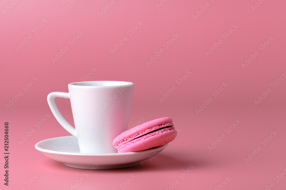 One pink macaroon with cup of coffee One pink macaroon with cup of coffee