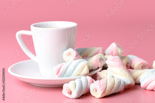 Twisted american marshmallow on pink background with coffee cup