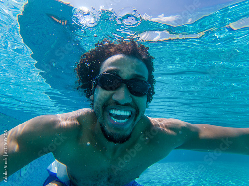 Beautiful young african american man diving in a swimming pool