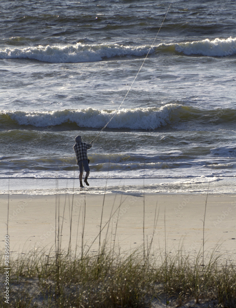 Man On a Beach Fly Fishes in the Turbulent Sea Man On a Beach Fly Fishes in the Turbulent Sea