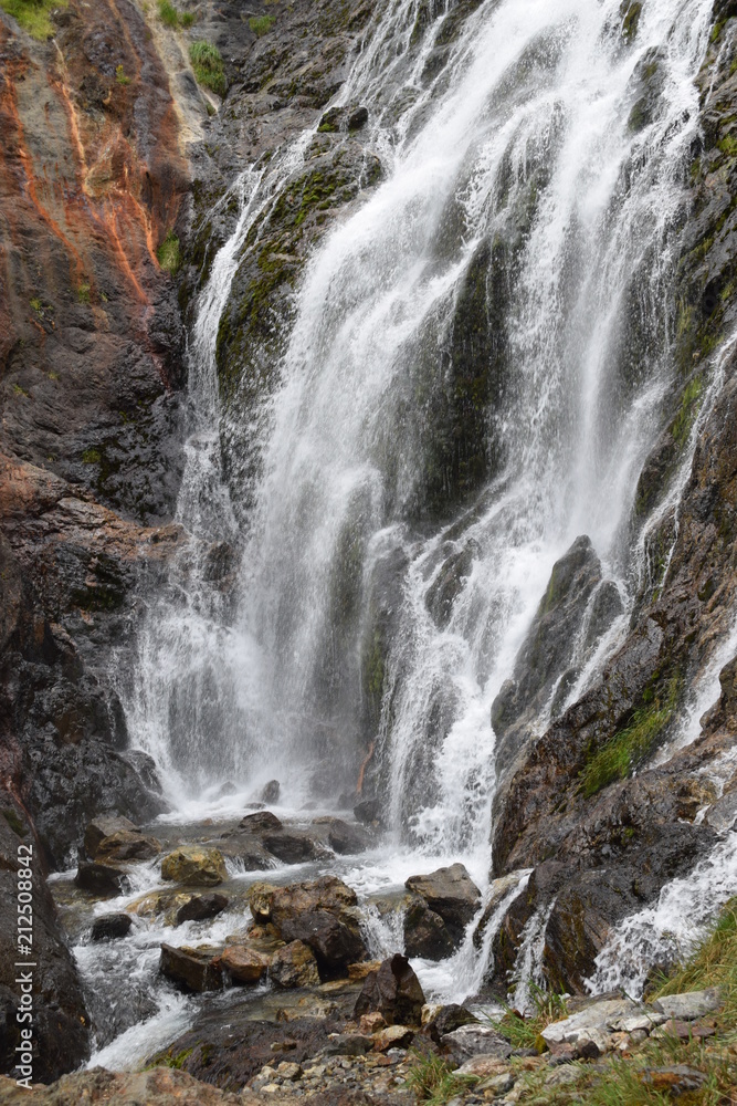 Naklejka premium Mountainous waterfall in a rocky place