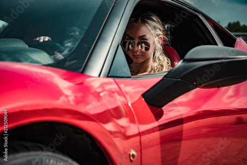 A girl in a red sports car.