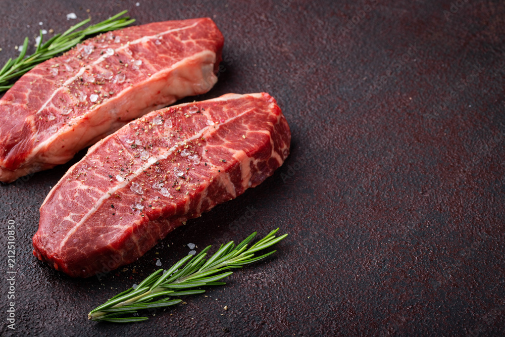 Raw fresh meat Top Blade steaks on dark background. top view with copy space