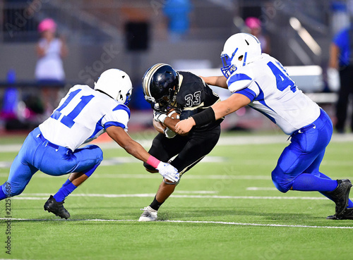 Fotografie Football player making a tackle during a game