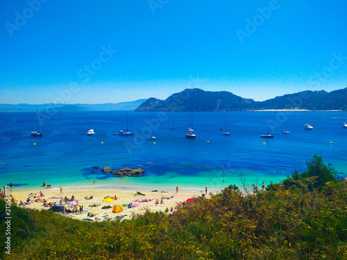 Beach of Cies Islands, in Galicia, Spain, with boats docked in front of