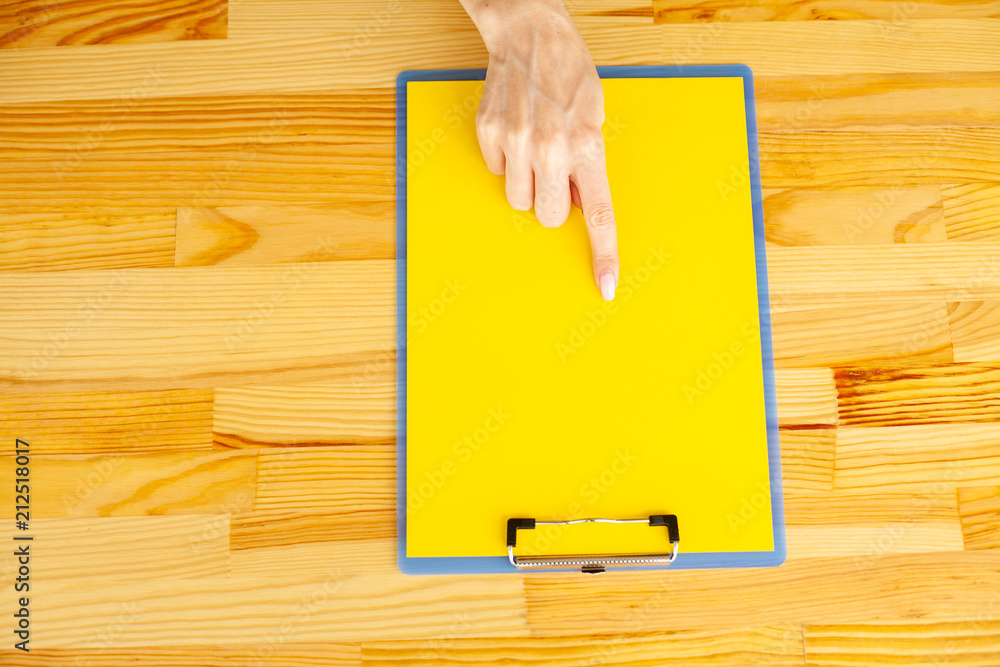 Blank Folder with Yellow Paper. Hand that Holding Folder and Handle on Wood Background. Copyspace. Place for Text. Blank Folder with Yellow Paper. Hand that Holding Folder and Handle on Wood Background. Copyspace. Place for Text.