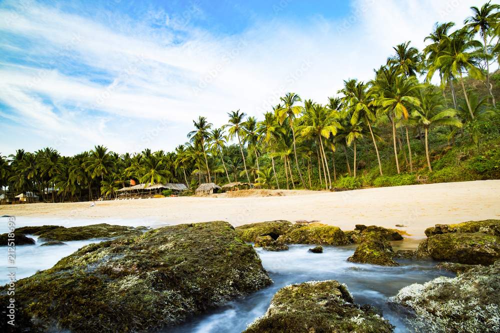 Long exposure. Beautiful and relaxing beach flanked by green palm trees at sunset. Varkala, Kerala, India.