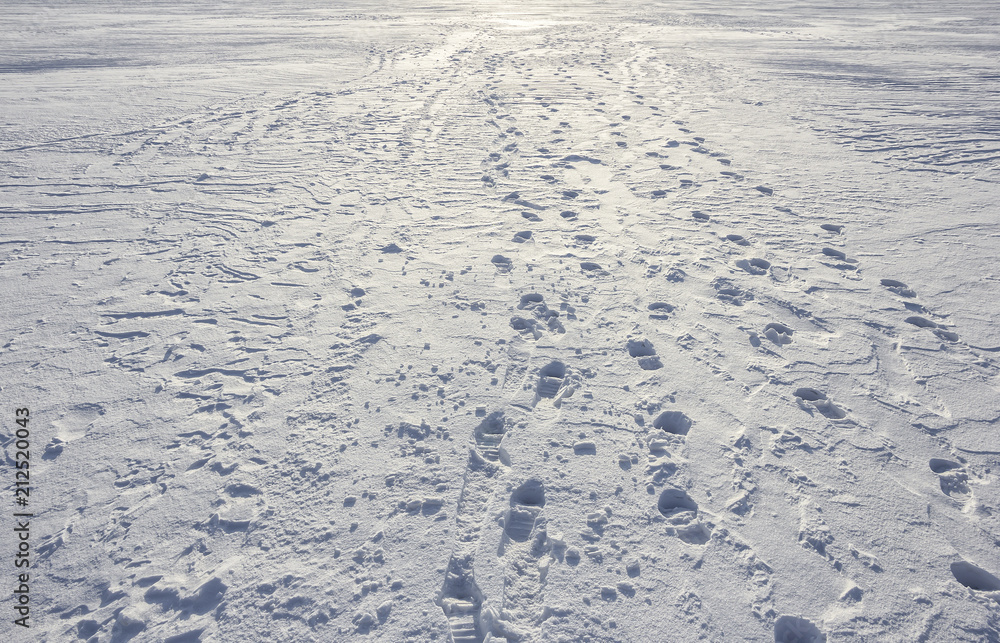 Footprints path crossing a snowy terrain, Traces on snow, background Footprints path crossing a snowy terrain, Traces on snow, background