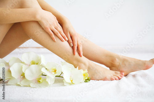 Fototapeta Naklejka Na Ścianę i Meble -  Spa. Woman massaging legs sitting on white background
