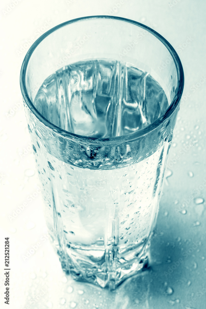 Glass of cold water with drops and reflection, view from above with selective focus, toned. Drink of health freshness aqua Glass of cold water with drops and reflection, view from above with selective focus, toned. Drink of health freshness aqua