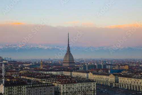 The Mole Antonelliana is seen in the middle. In the background there are the alps during a sunset in Turin, Piedmont, Italy. © Alexander