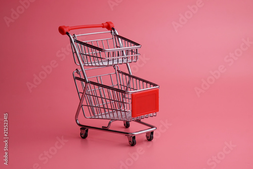 Shopping trolley on pink background
