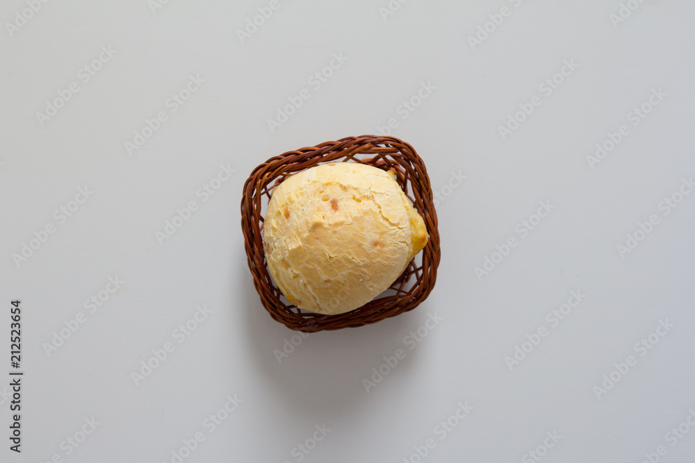 Pao de Queijo is a cheese bread ball from Brazil. Also known as Chipa, Pandebono and Pan de Yuca. One snack in basket over white background, minimalism. - obrazy, fototapety, plakaty 