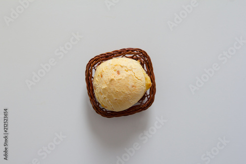 Pao de Queijo is a cheese bread ball from Brazil. Also known as Chipa, Pandebono and Pan de Yuca. One snack in basket over white background, minimalism. photo